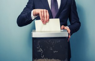 A Businessman is shredding important documents